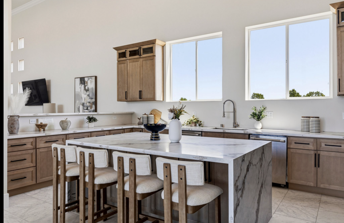 The main kitchen was remodeled with a waterfall island, Thermador appliances and warm-toned cabinetry to open up river views.